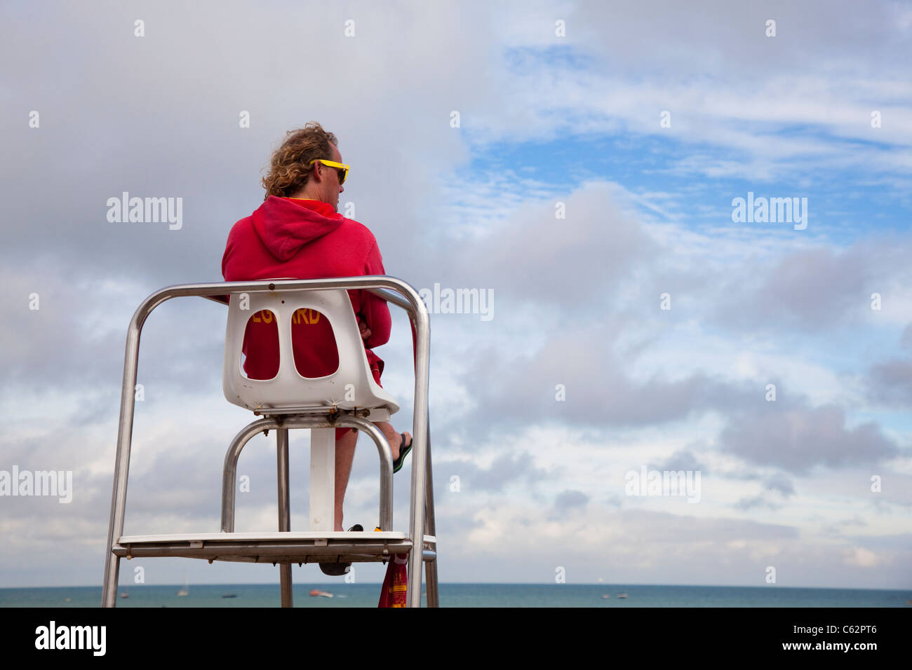 A Lifeguard diligently watches bathers at Eastbourne, East Sussex, UK