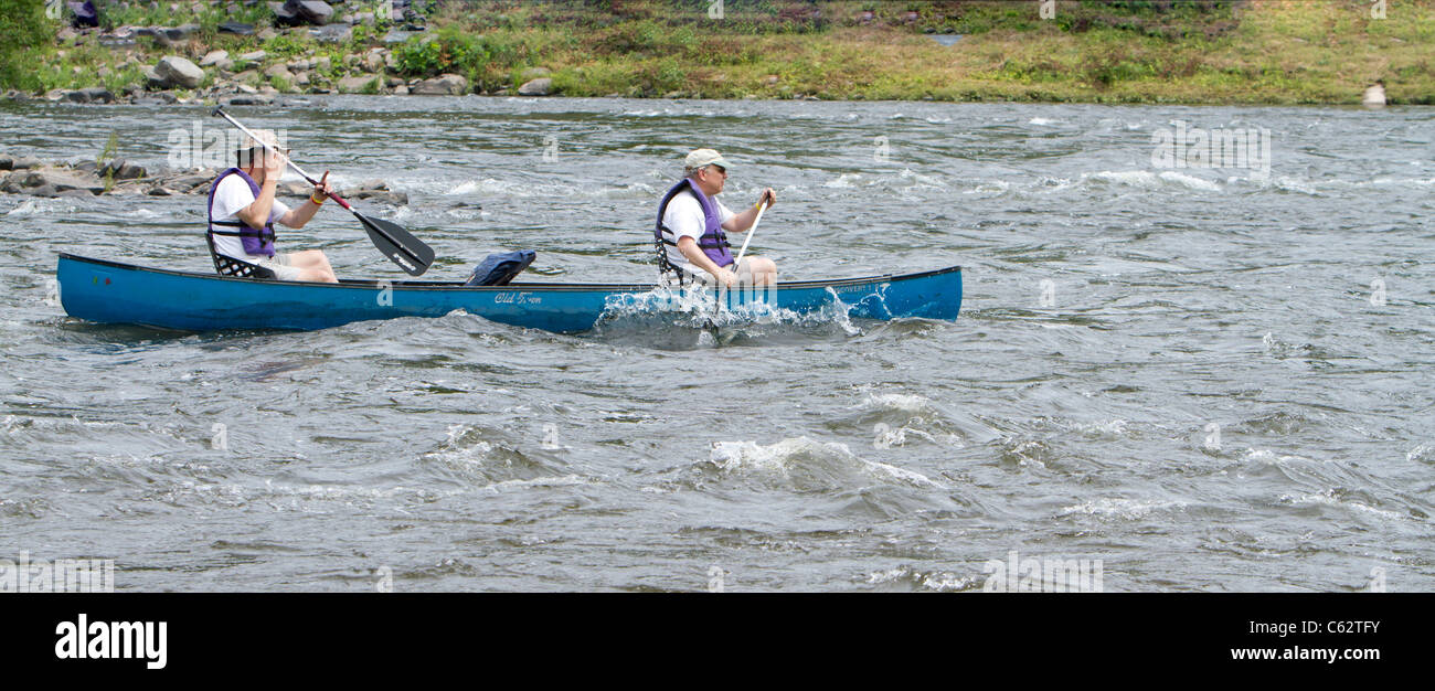 Two senior men paddling in a canoe in river rapids Stock Photo Alamy