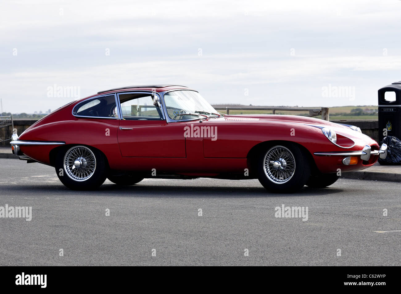 Side profile of red E-type Jaguar in 50th anniversary year on car park Stock Photo