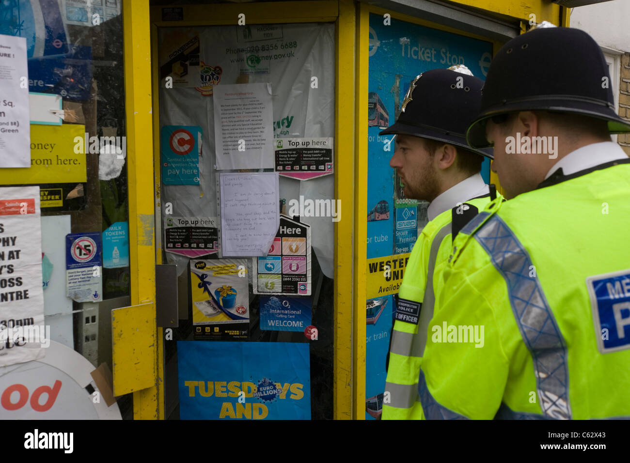 Two Metropolitian Police Officers stop to view the Clarence Road Convenience Store, looted in the 2011 riots. Stock Photo