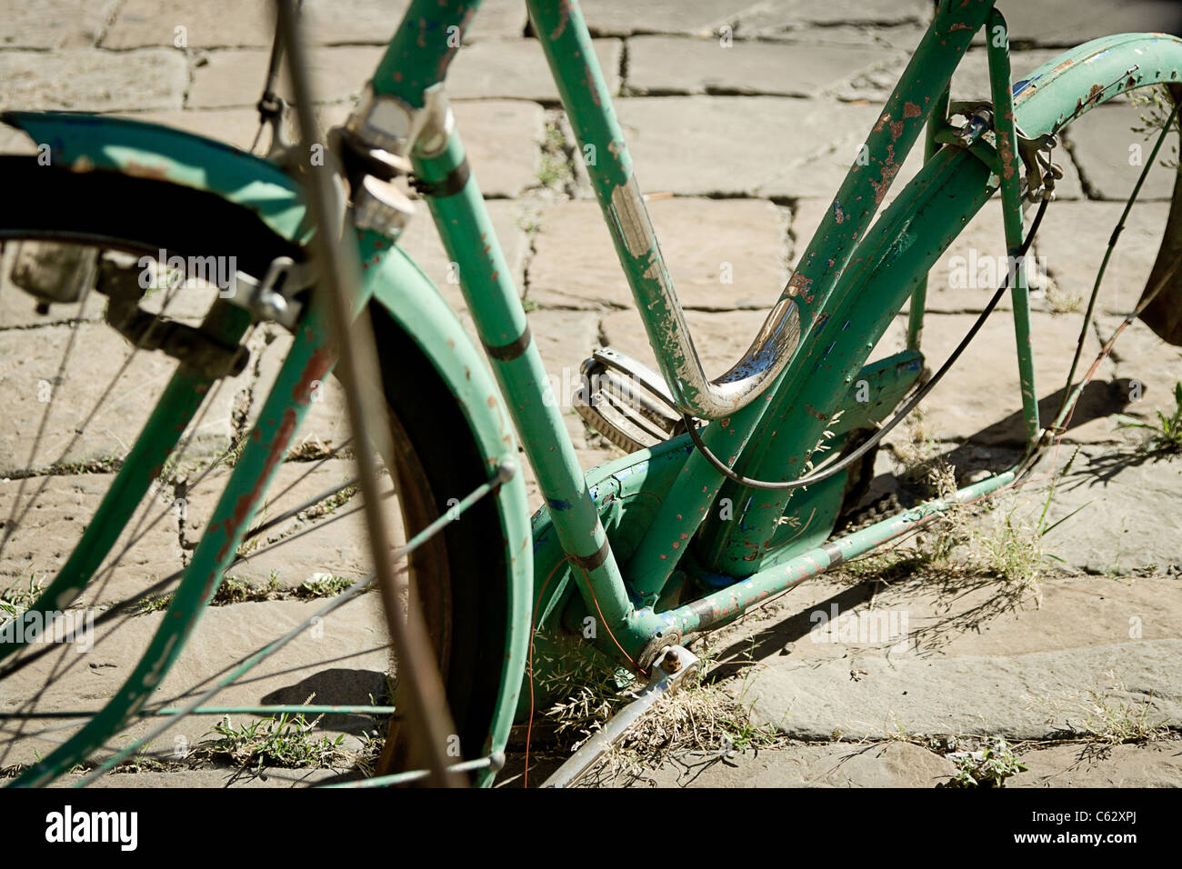 A broken and abandoned bicycle on an urban street Stock Photo