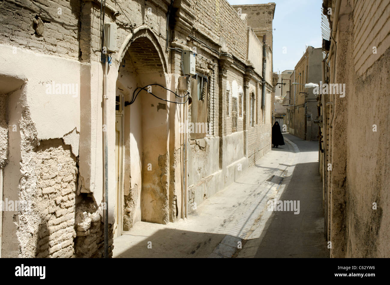 Woman in chador walking in one of the old alleyways of down town Tehran. Stock Photo