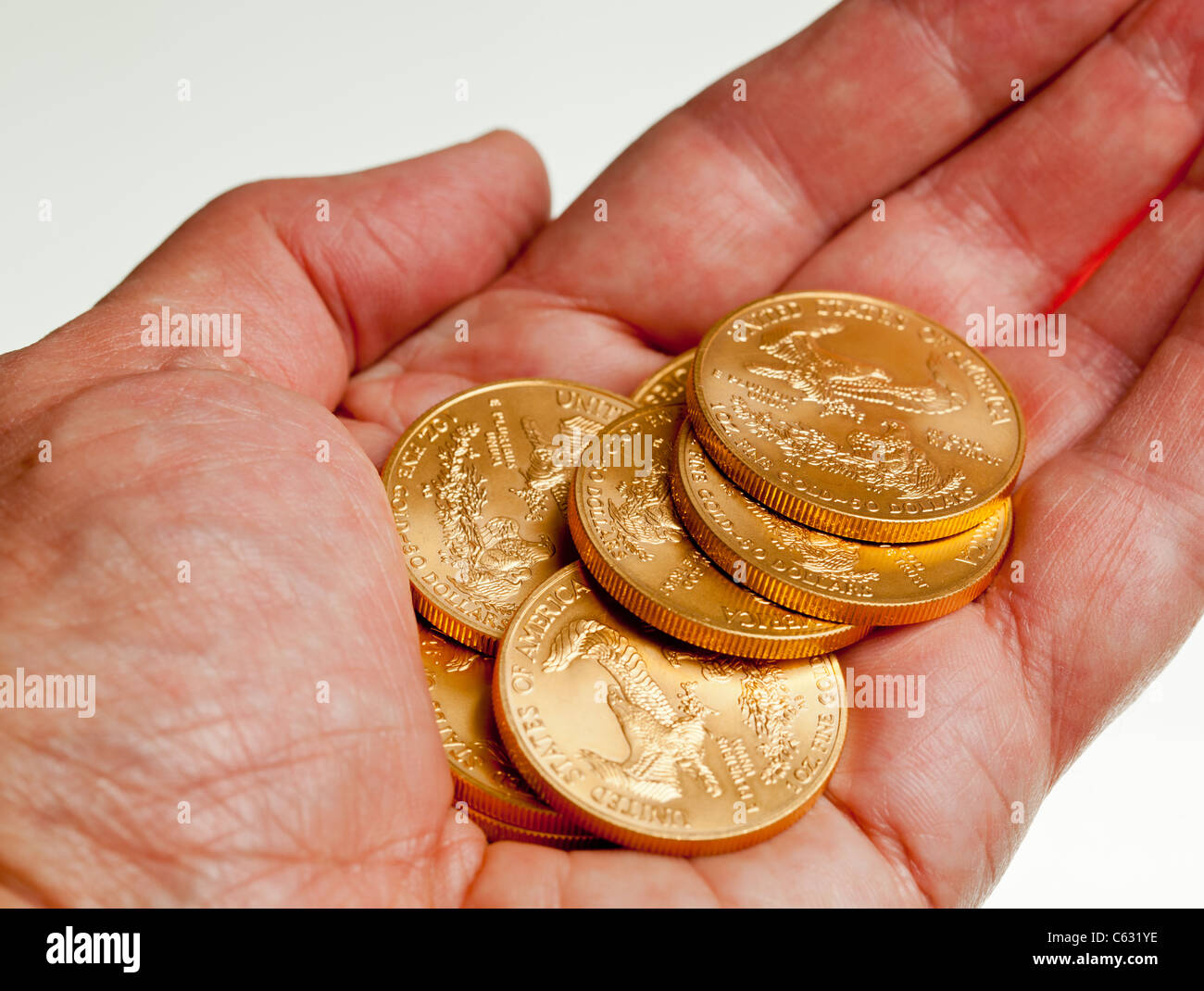 Gold Eagle one ounce coins in a stack in the palm of a hand Stock Photo Alamy