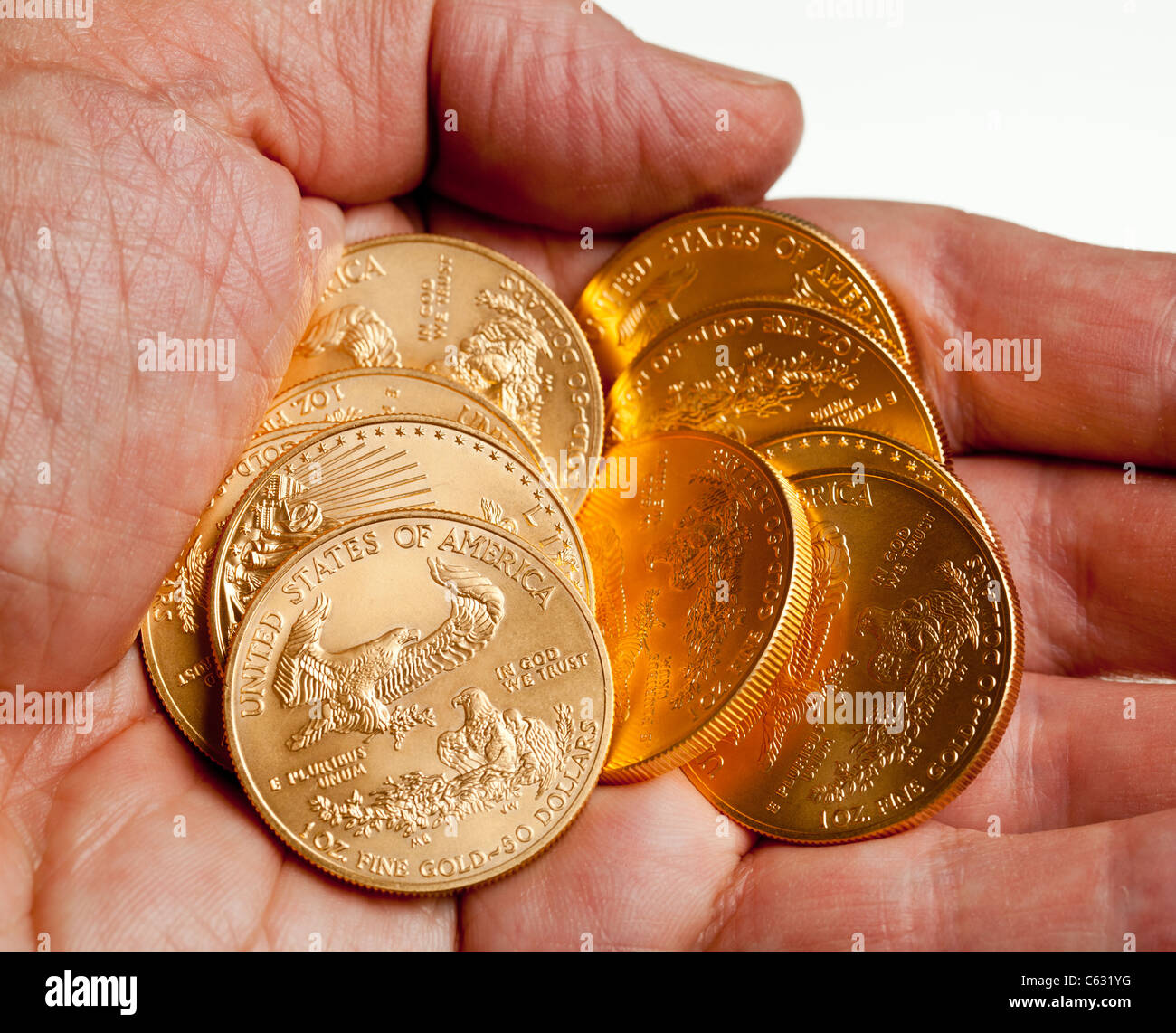 Gold Eagle one ounce coins in a stack in the palm of a hand Stock Photo Alamy