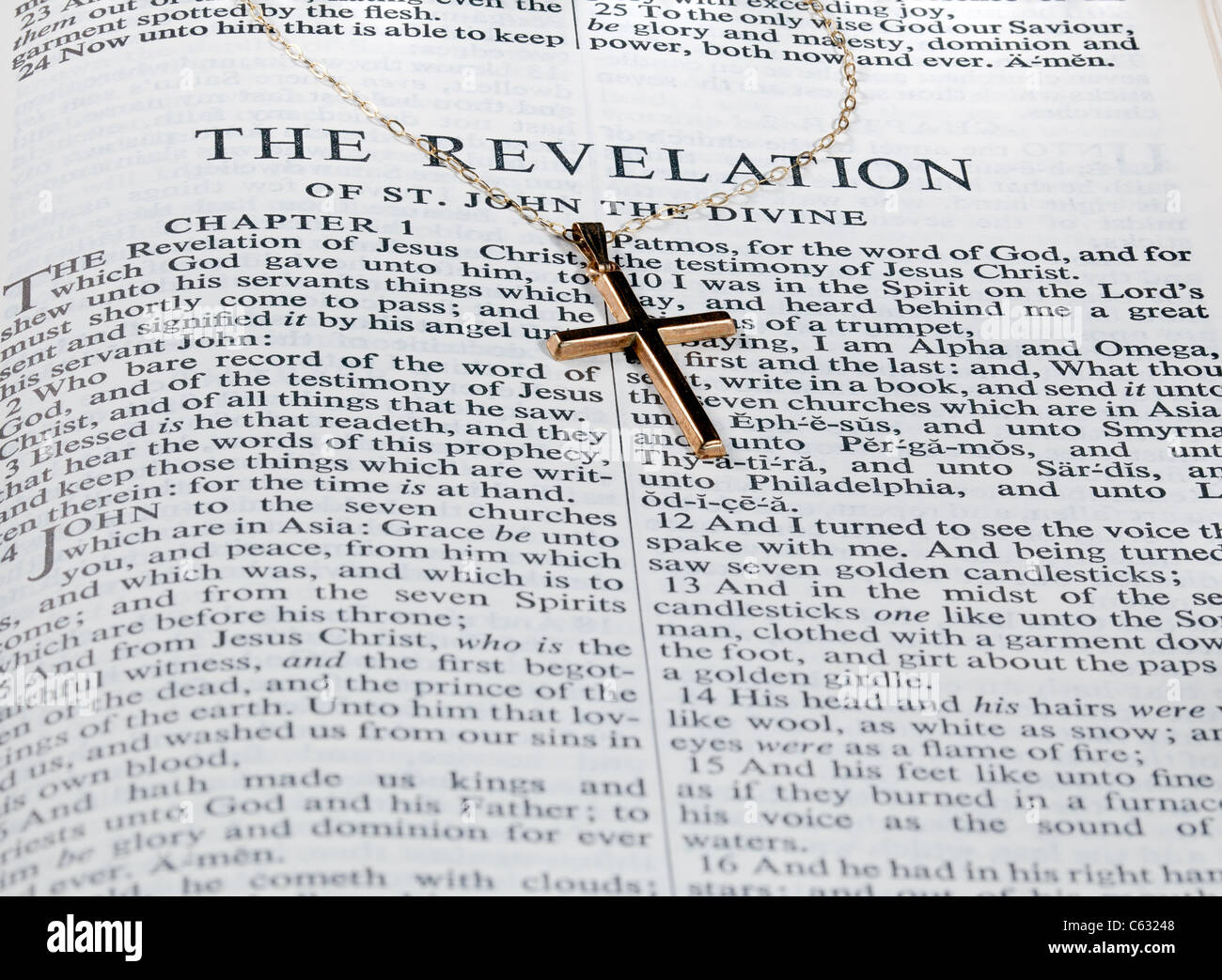 Gold crucifix / cross and chain on an open Bible at the book of The