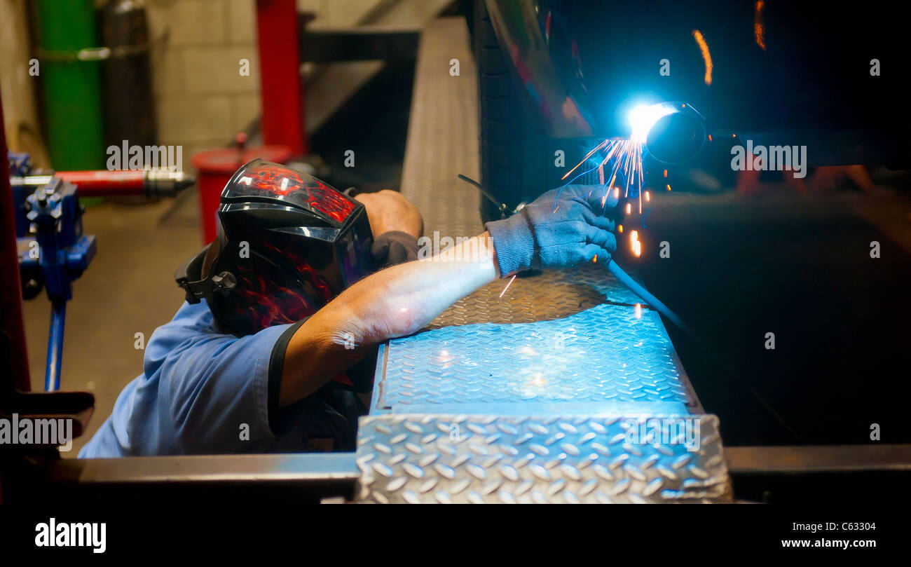 Mechanic soldering a muffler Stock Photo Alamy