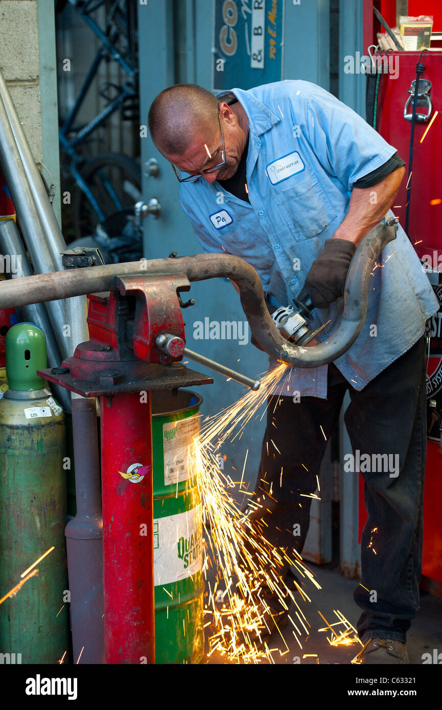 a Mechanic cuts a muffler pipe Stock Photo Alamy