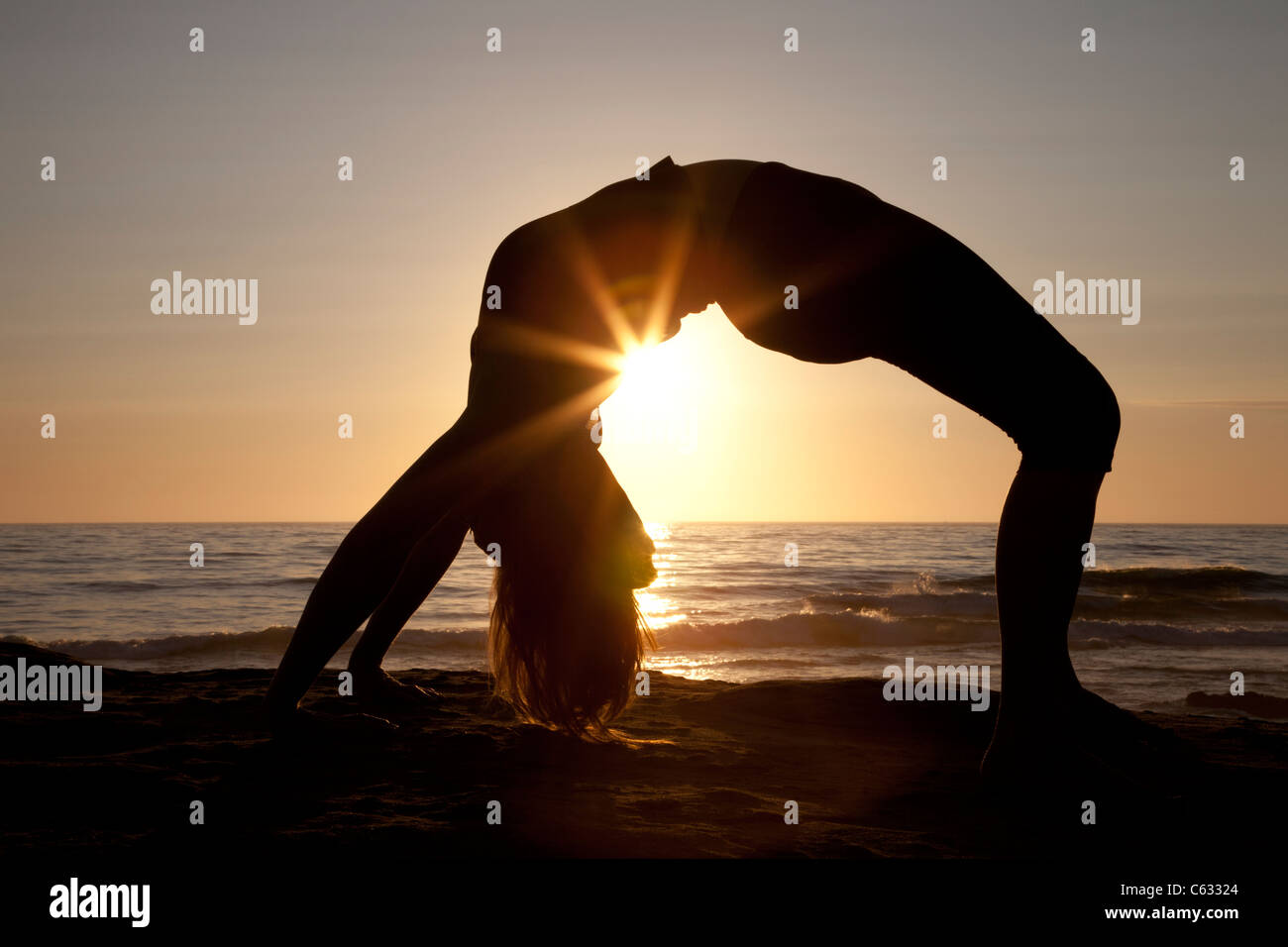 Woman practicing yoga on Windnsea beach at sunset, La Jolla, California Stock Photo