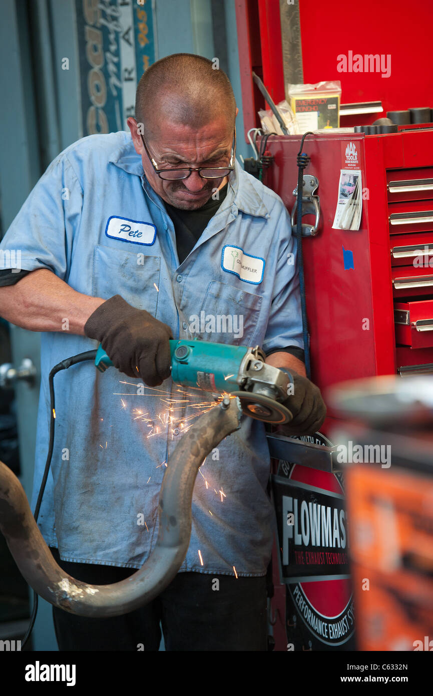 a Mechanic cuts a muffler pipe Stock Photo Alamy