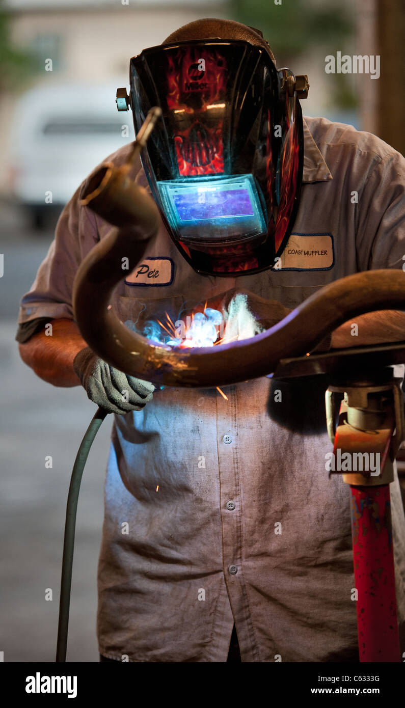 Mechanic soldering a muffler Stock Photo Alamy