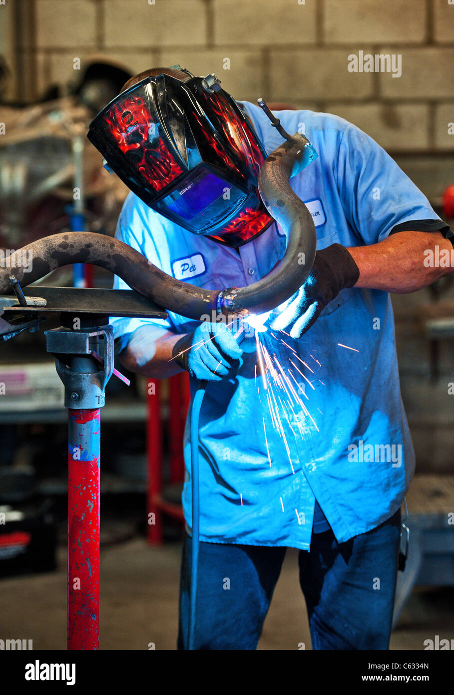 Mechanic soldering a muffler Stock Photo Alamy