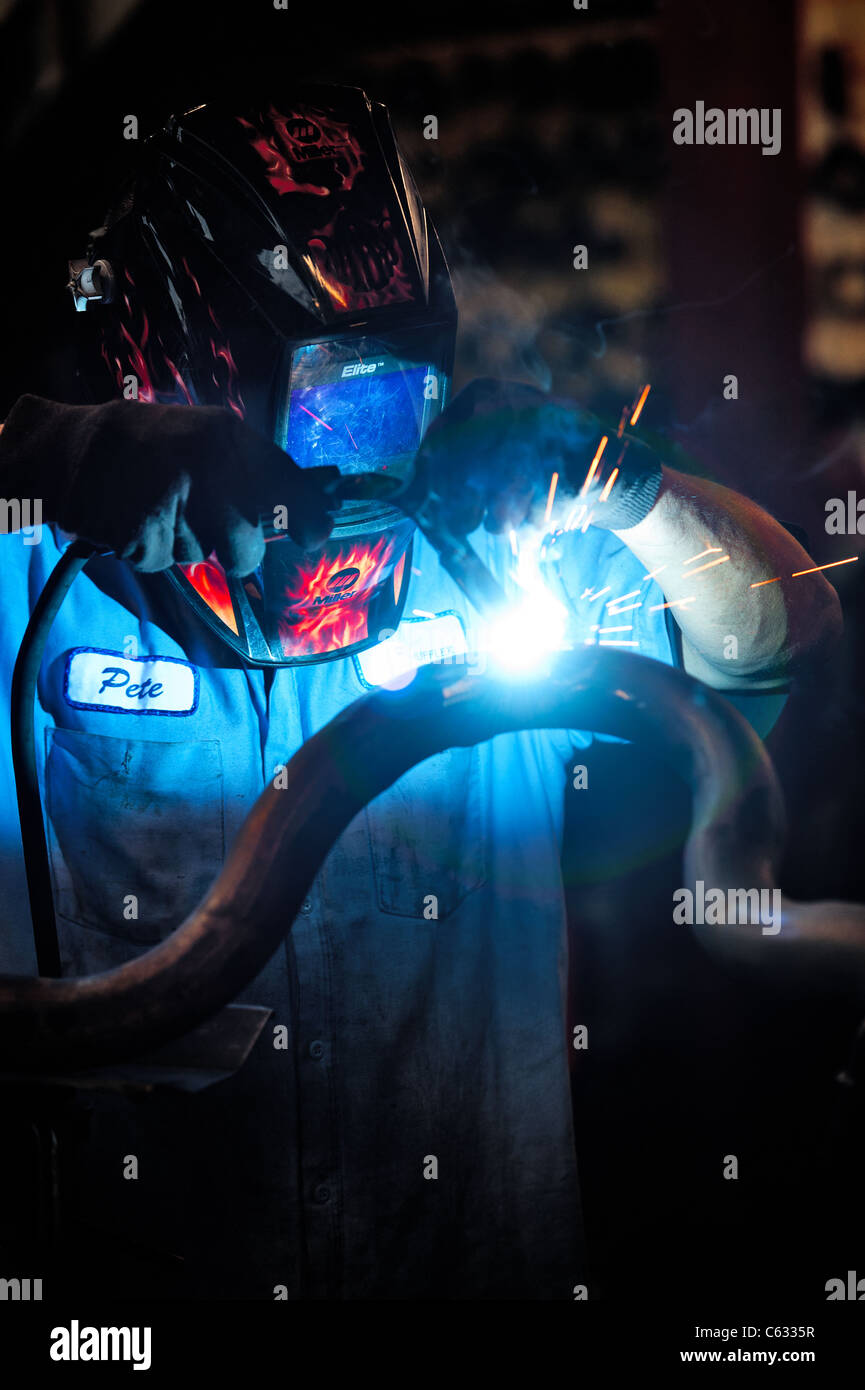 Mechanic soldering a muffler Stock Photo Alamy