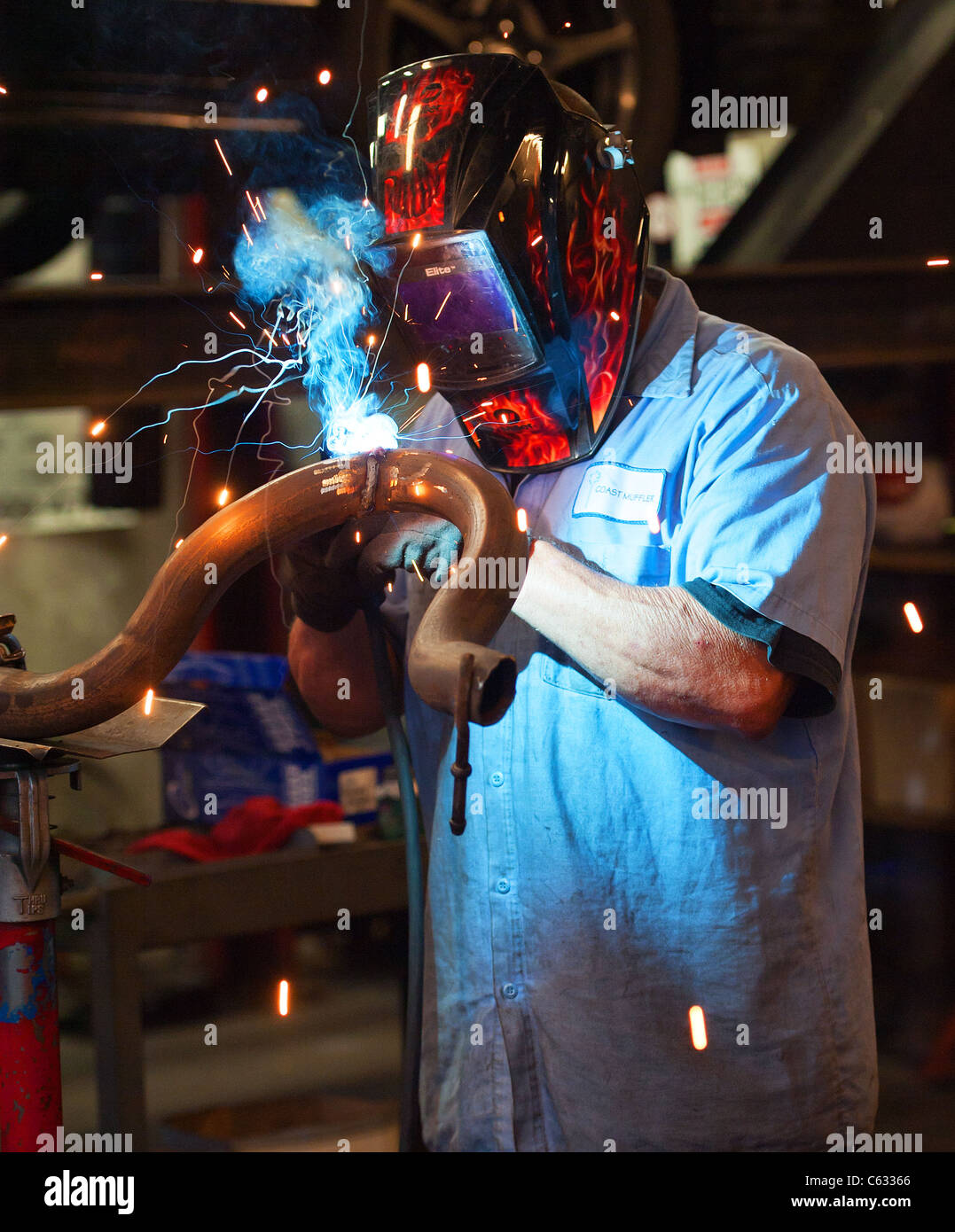 Mechanic soldering a muffler Stock Photo Alamy