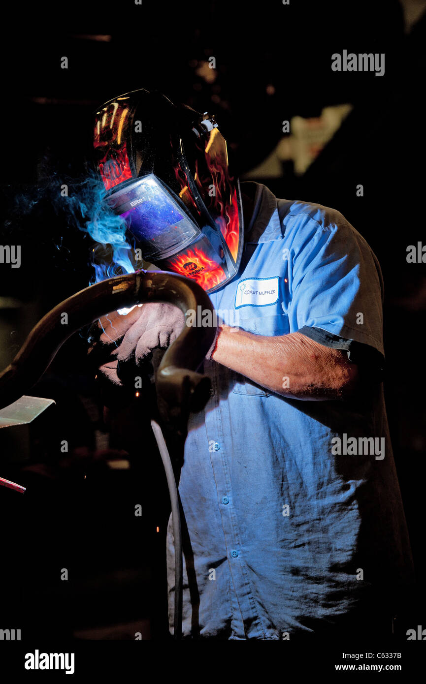 Mechanic soldering a muffler Stock Photo Alamy