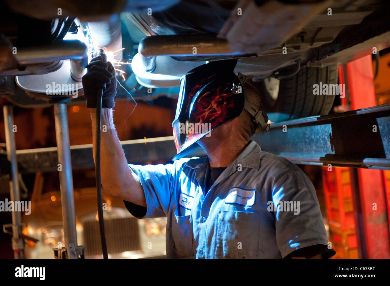 Mechanic soldering a muffler Stock Photo Alamy