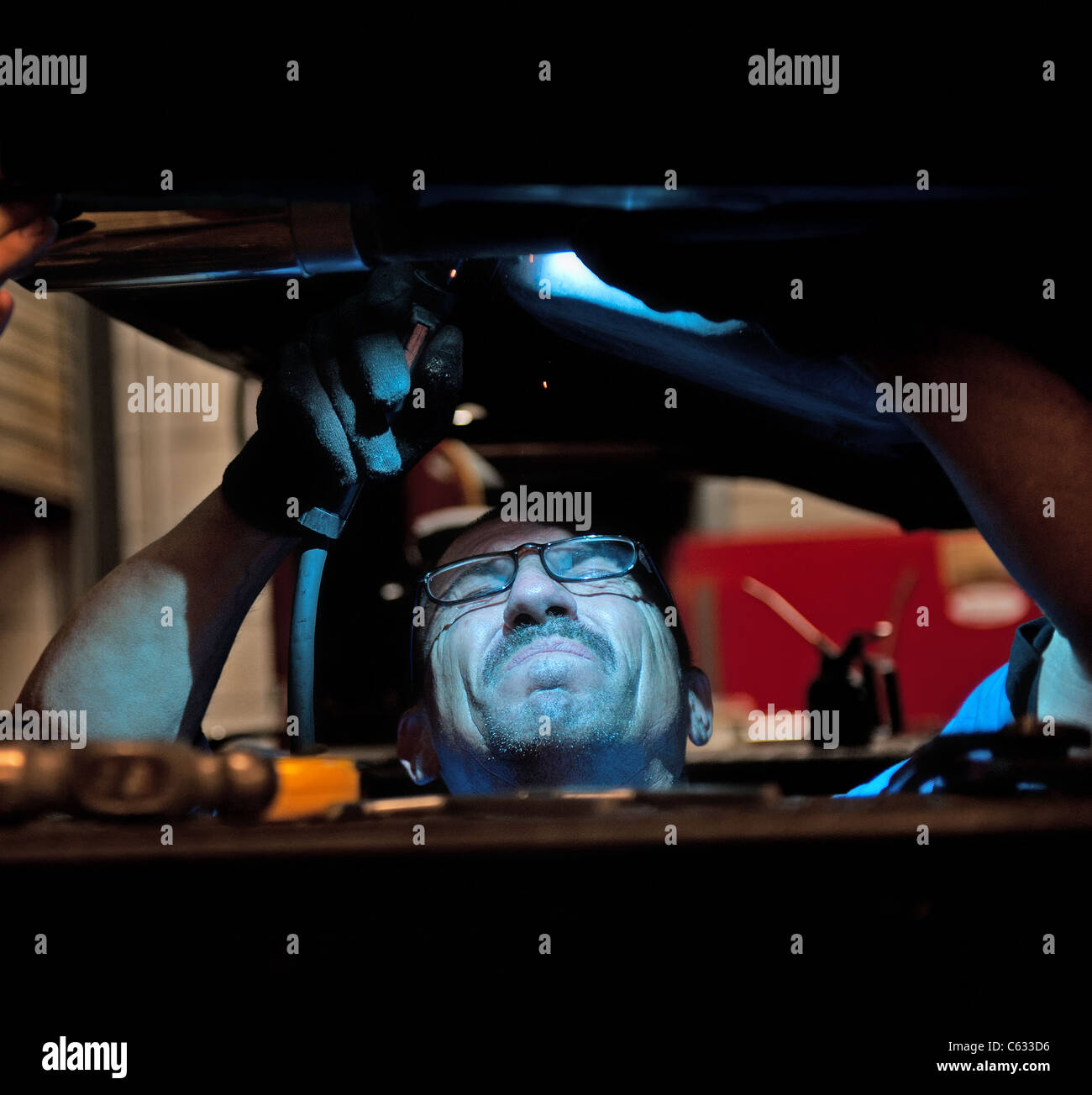 Mechanic soldering a muffler Stock Photo Alamy