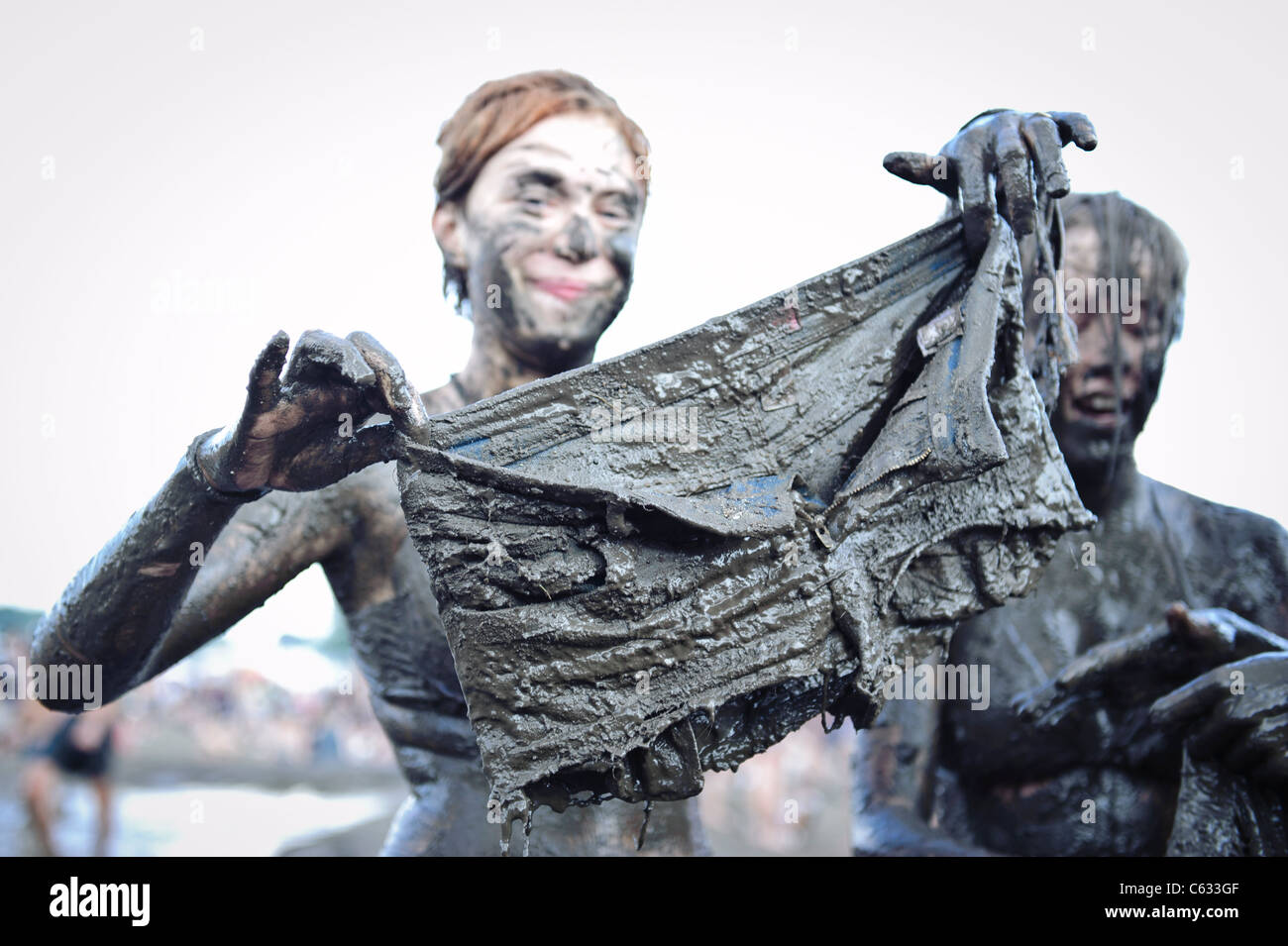 woman showing her clothes covered in mud at the Przystanek Woodstock ...