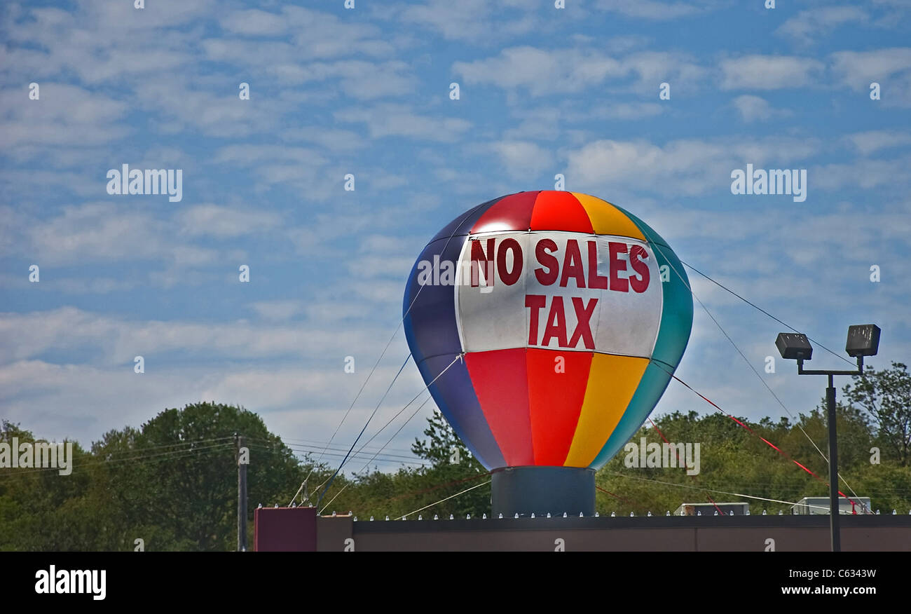 This stock image shows a multi-colored no sales tax writing sign on a big hot air balloon against a beautiful daytime sky. Stock Photo