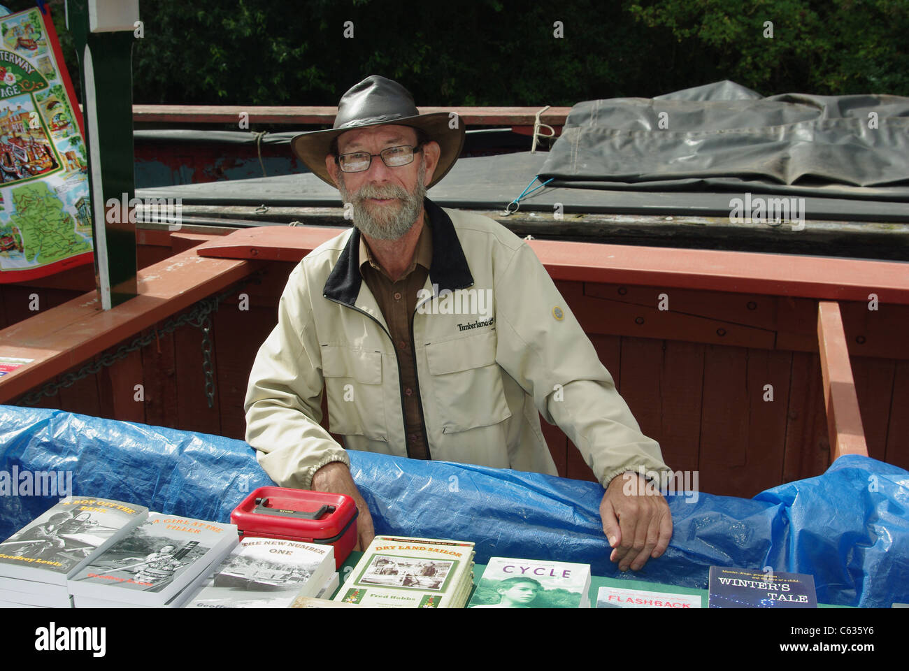 Local author Geoffrey Lewis selling his work from the narrowboat 'Raymond' at the Blisworth Canal Festival, 2011 Stock Photo