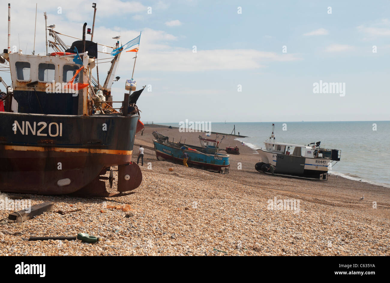 Hastings has the largest beach-based fishing fleet in England. Returning fishing boats being winched up onto Harbour Beach. Stock Photo