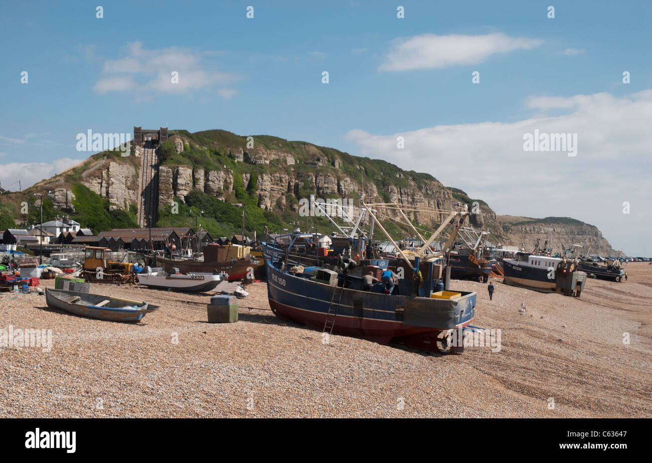 Hastings has the largest beach-based fishing fleet in England. Returning fishing boat being winched up onto Harbour Beach. Stock Photo