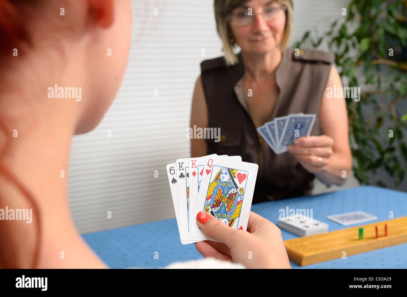 Mother With Crib Playing Cribbage Card Game With Young Daughter