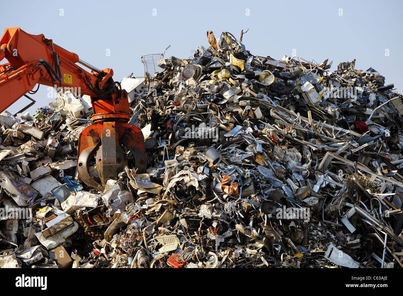 Crane grabber loading rusty scrap metal for recycling Stock Photo
