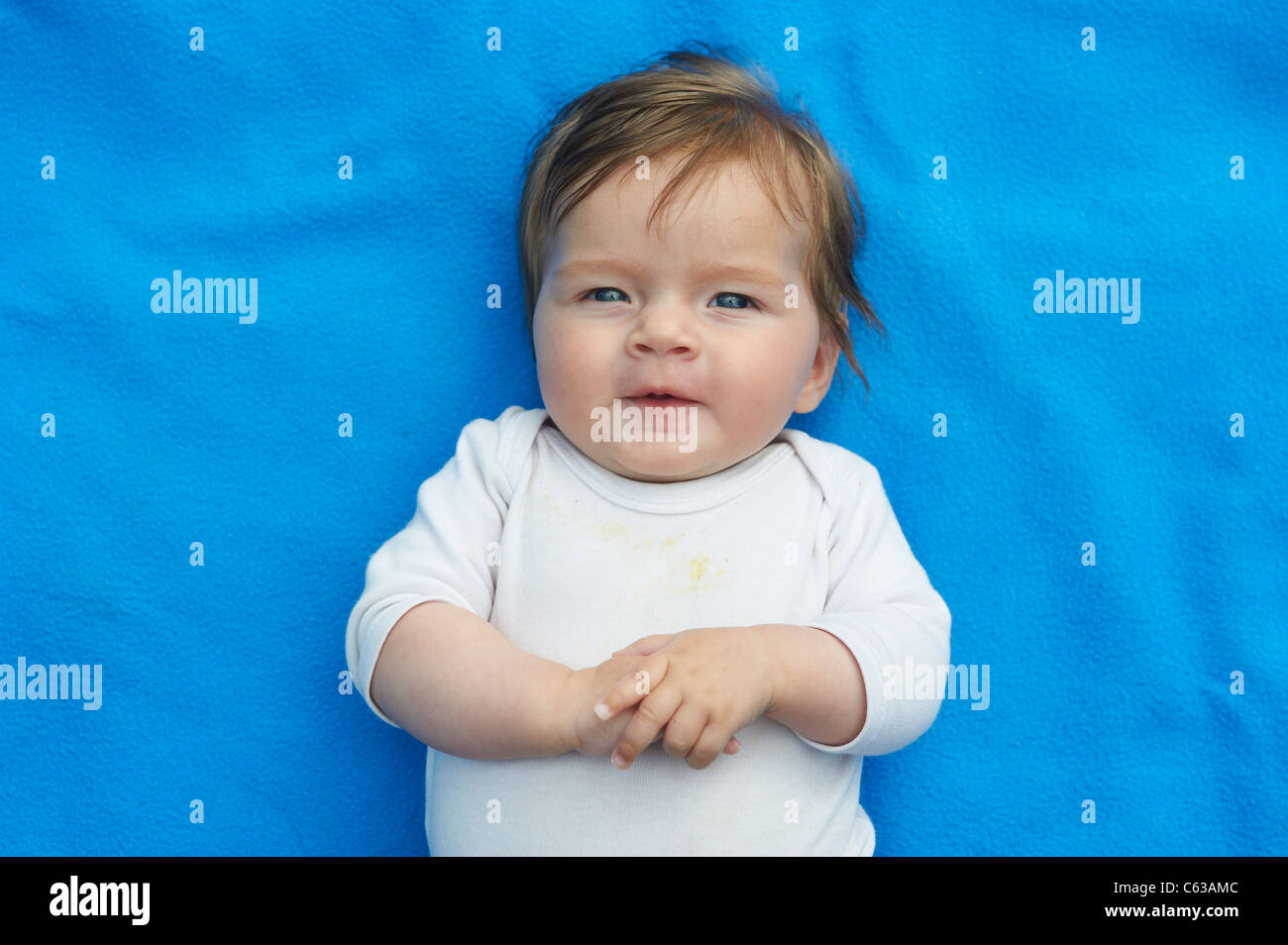 Little baby girl lying on blue blanket in grass outside Stock Photo Alamy