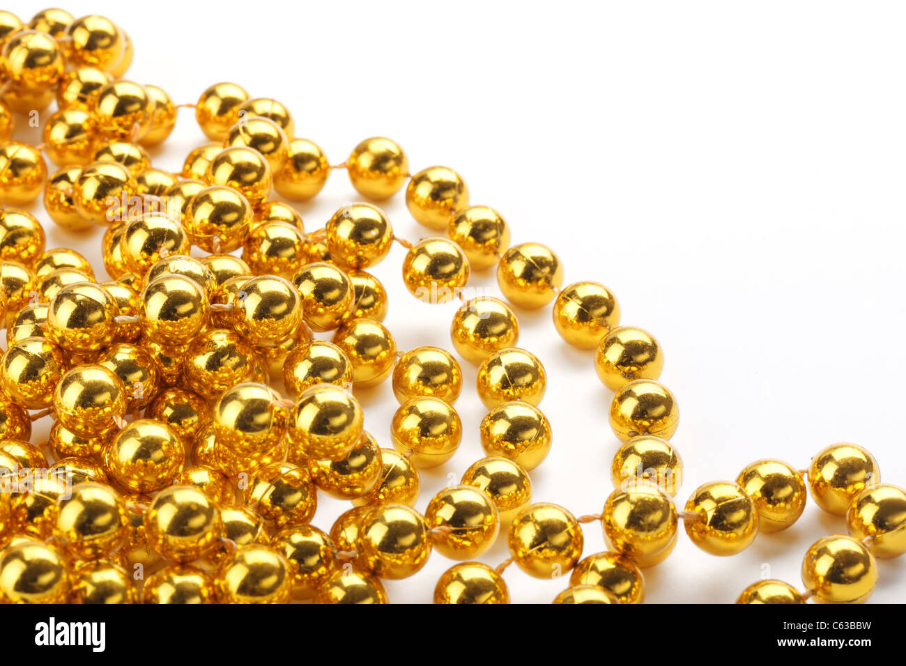 Golden color beads on white background. Stock Photo