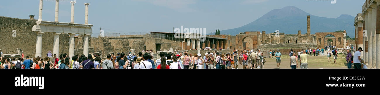 Pompeii Italy historic ruins with hundreds of tourists looking at the archeology site. Columns and remains of walls. Stock Photo