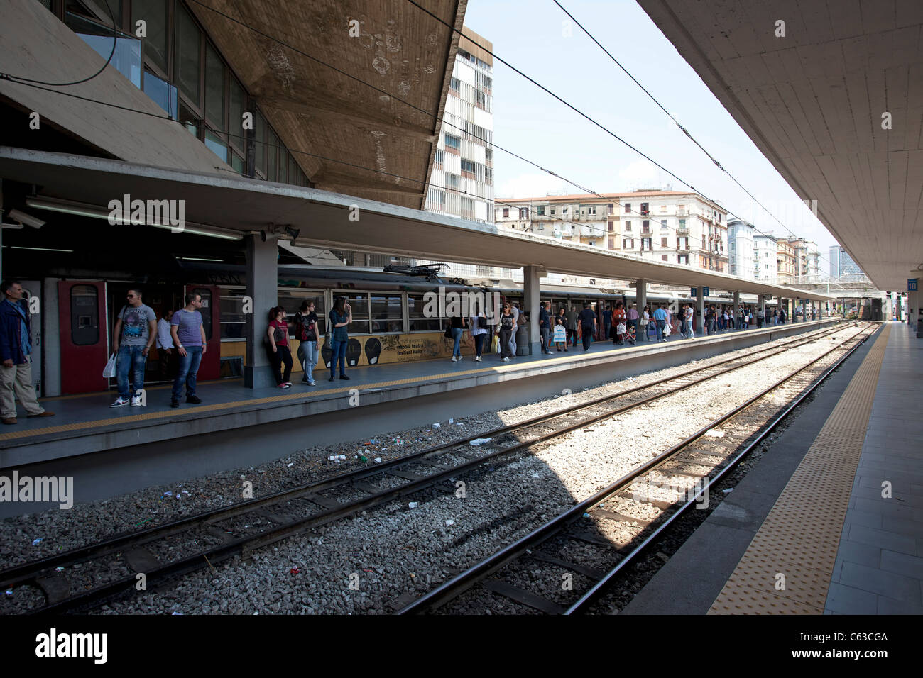 Train station in Naples, Italy showing modern buildings, with waiting crowds, and railroad Train station in Naples, Italy showing modern buildings, with waiting crowds, and railroad