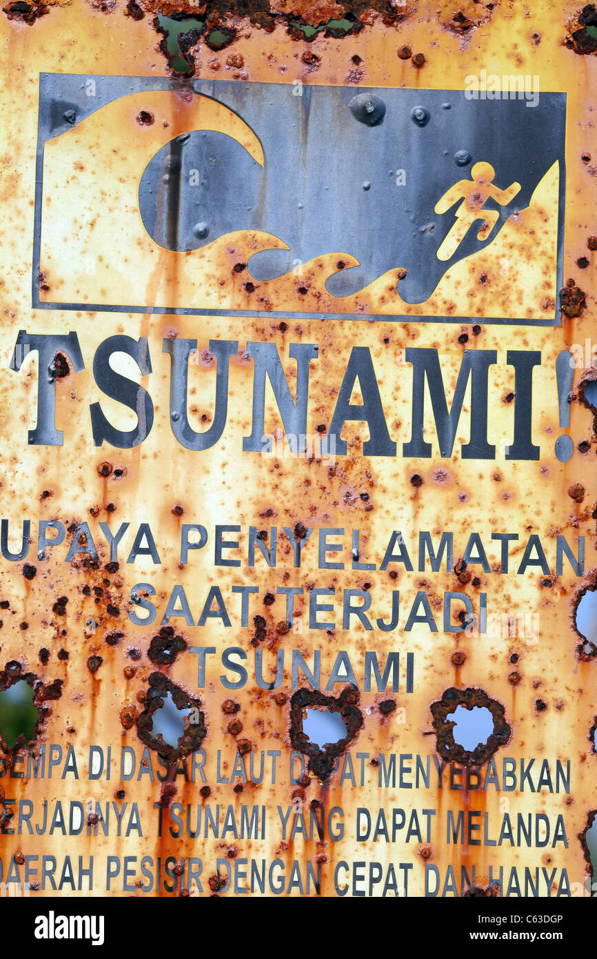 Rusting tsunami evacuation warning sign on Sekongkang Beach in Nusa Tenggara, Indonesia. Stock Photo