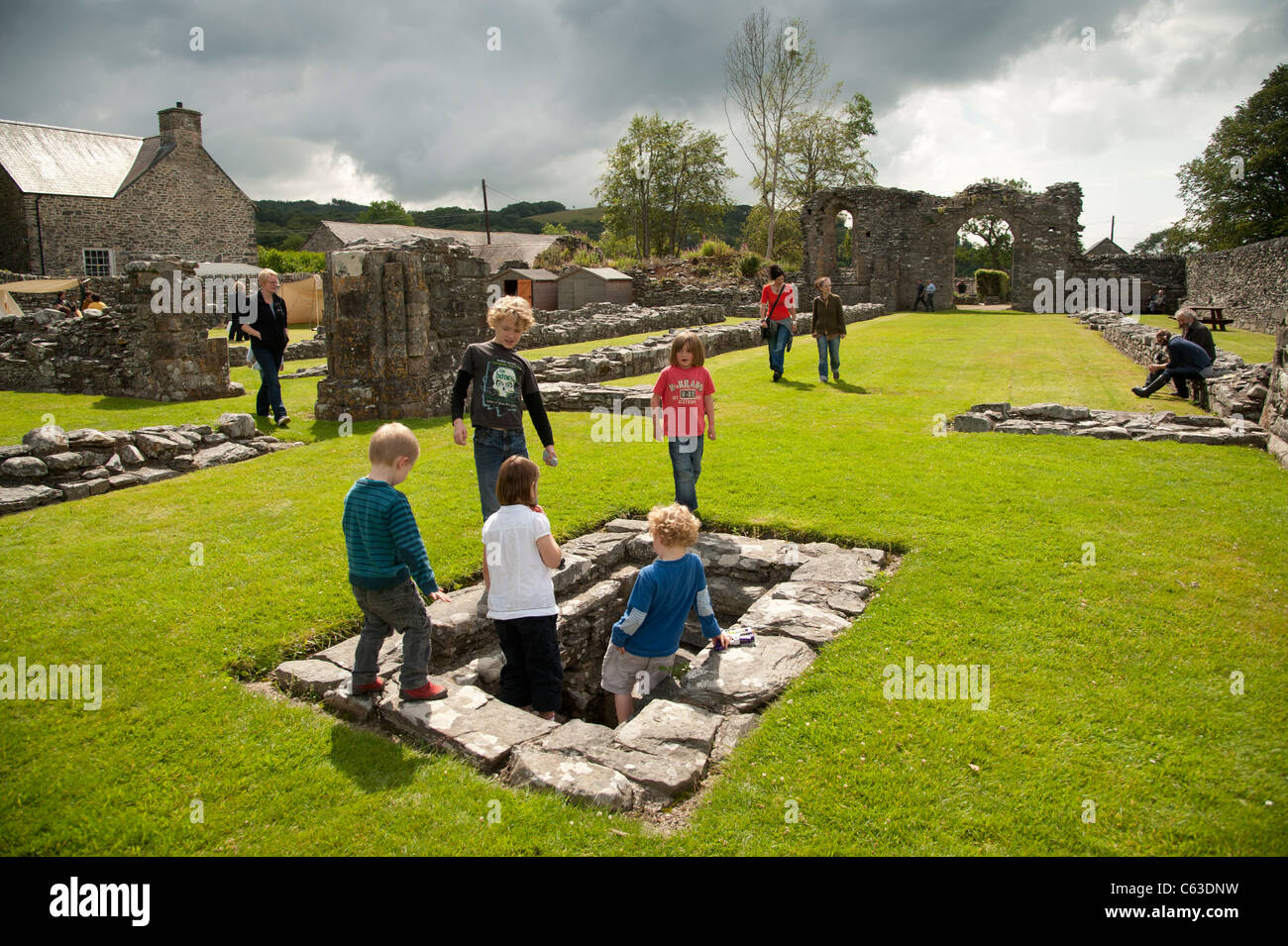 Visitors at Strata Florida / Ystrad Fflur ruined abbey, in the care of CADW, Ceredigion Wales UK Stock Photo