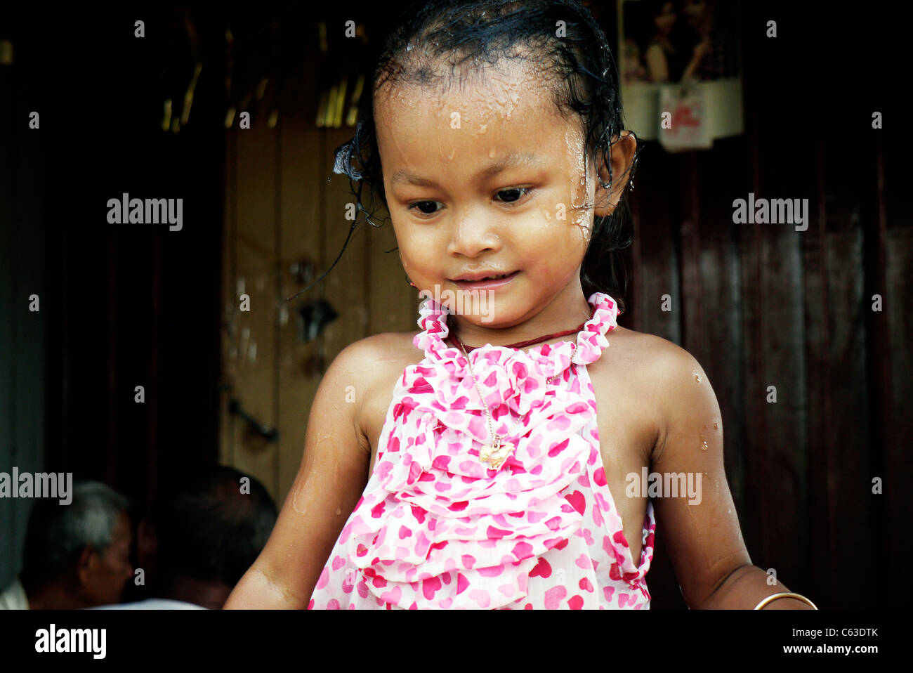 Girl, child, playing, taking a bath, Cambodian, home,sit, wall, Stock Photo