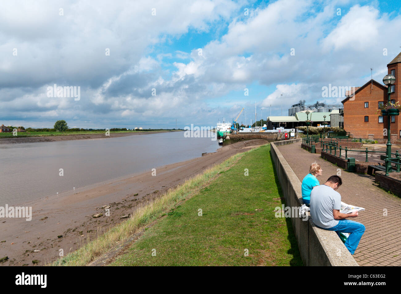 Two people relaxing on the side of the River Ouse in King's Lynn, Norfolk Stock Photo
