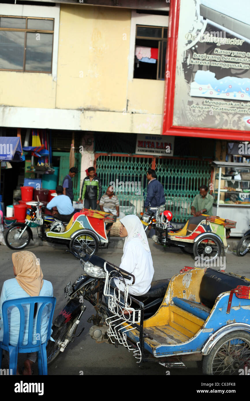 Muslim women and motor taxi drivers in the city center. Banda Aceh, Aceh, Sumatra, Indonesia, Southeast Asia, Asia Stock Photo