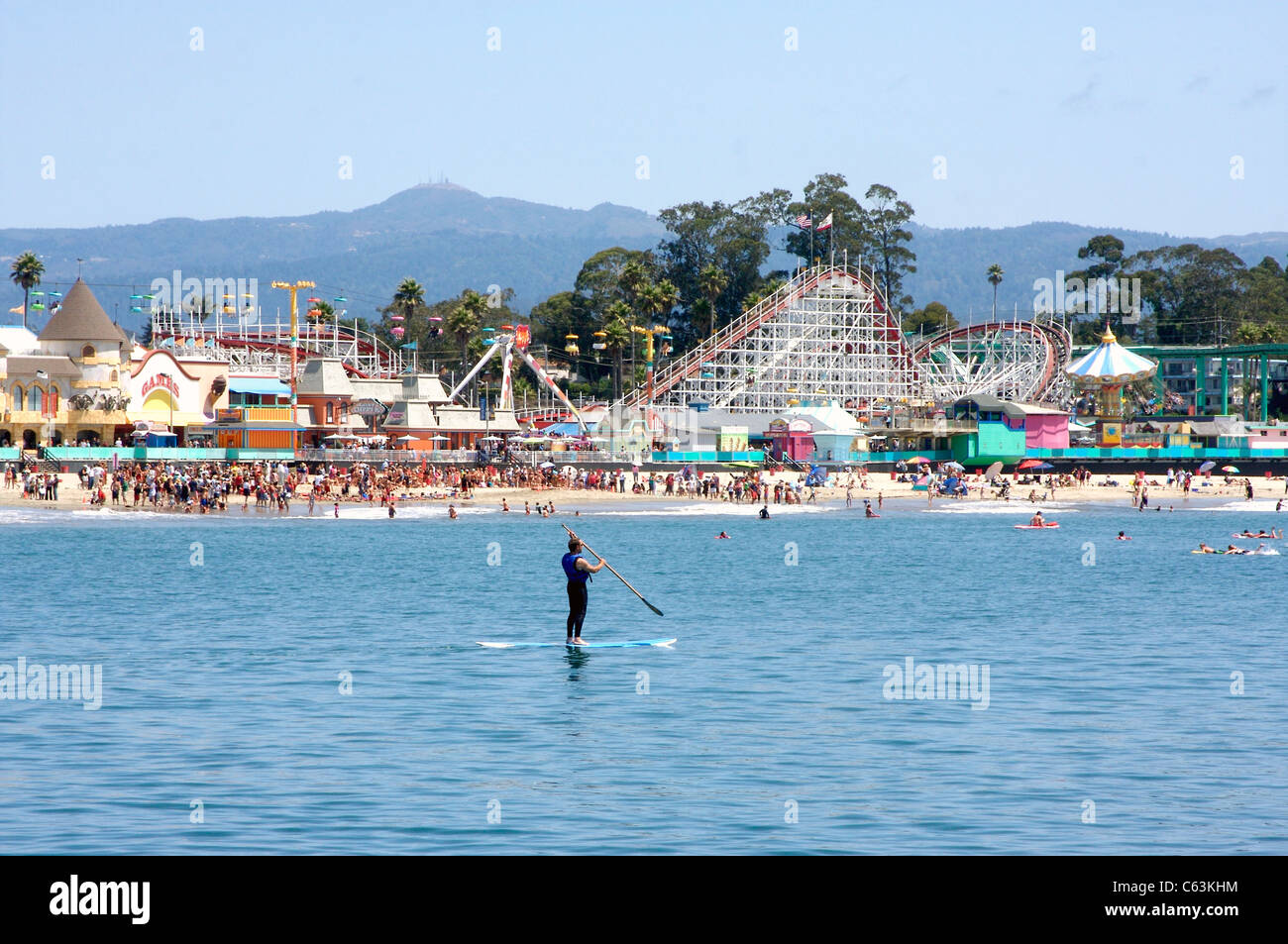 Man Paddleboarding by the Santa Cruz Beach Boardwalk in Santa Cruz, California Stock Photo