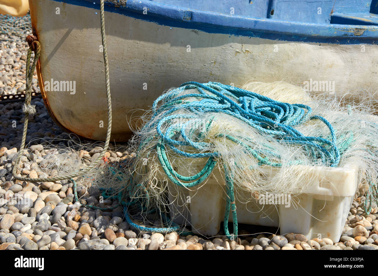 Nylon fishing net and synthetic rope beside a small fishing boat