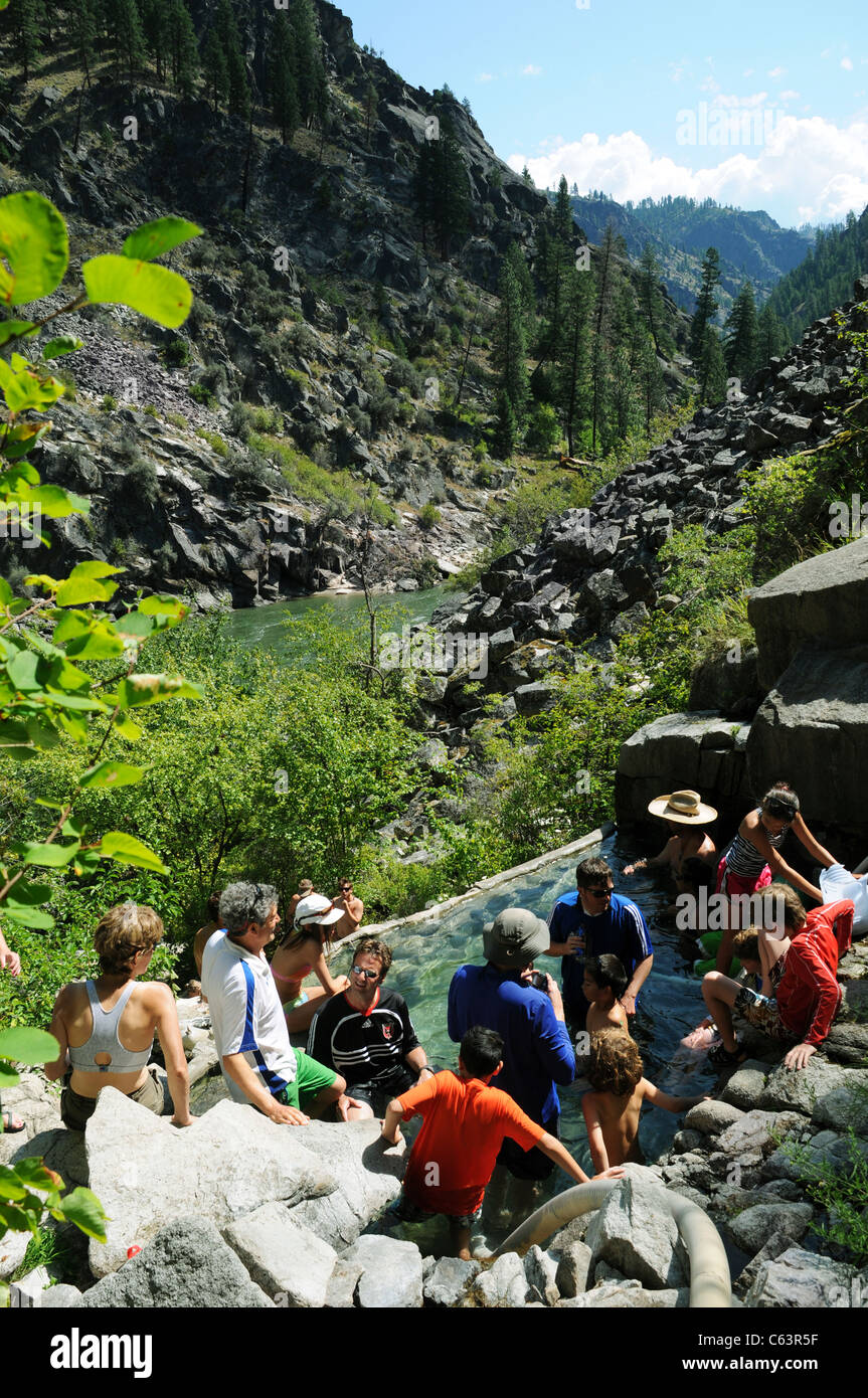 Adults and kids in natural mountain hot springs above Main Salmon River in Salmon River Mountains of Idaho Stock Photo