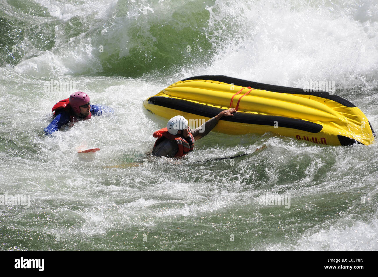 Flipping two man inflatable kayak with O.A.R.S. in whitewater at