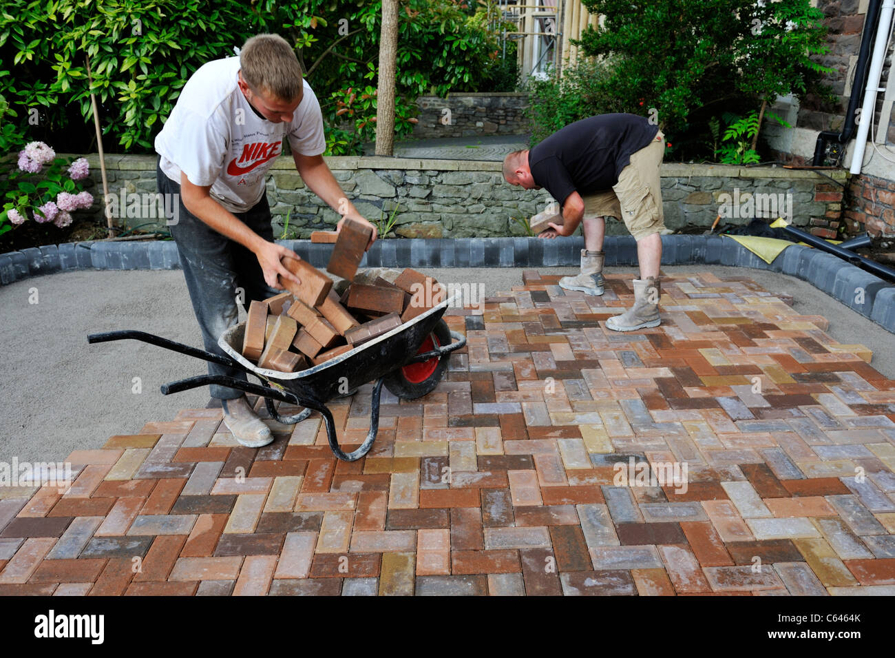 Builders laying block paving Stock Photo Alamy