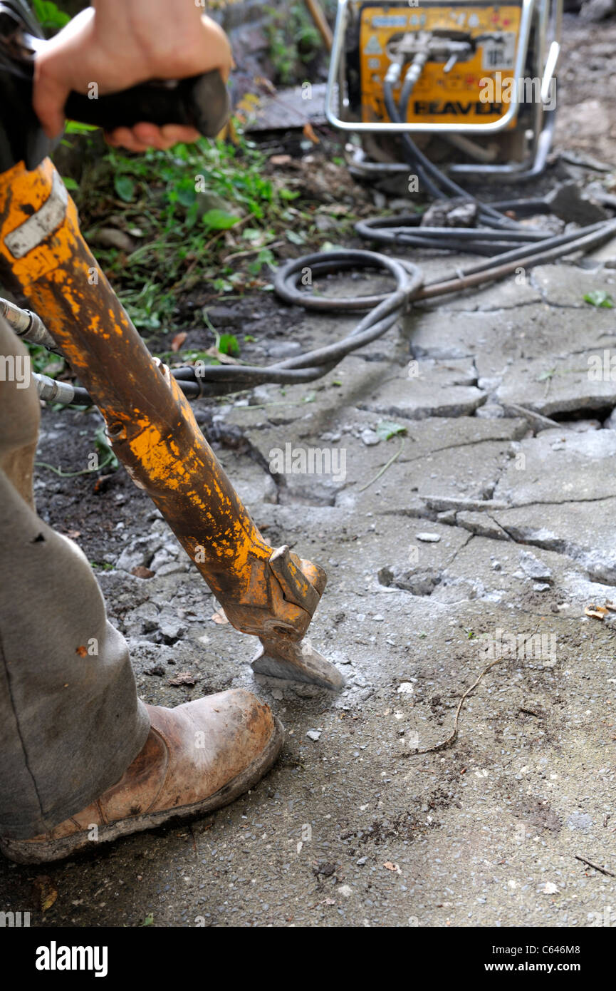 Workman using jack hammer to break up concrete Stock Photo Alamy