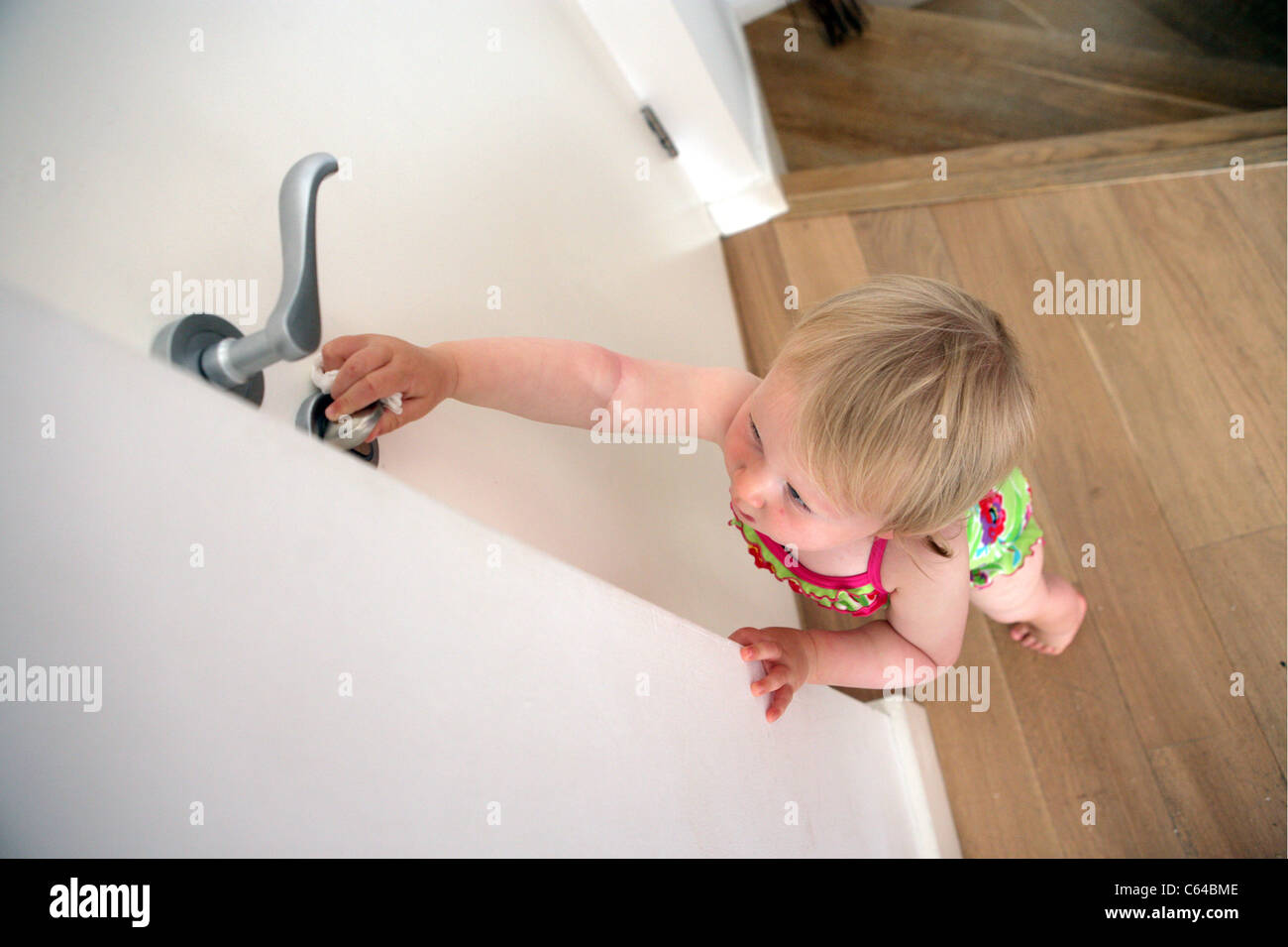 Toddler trying to open the front door Stock Photo Alamy
