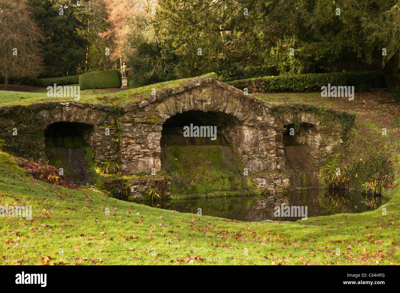The rustic stone arches of the lower cascade within the Venus Vale of Rousham House gardens, Oxfordshire, England Stock Photo