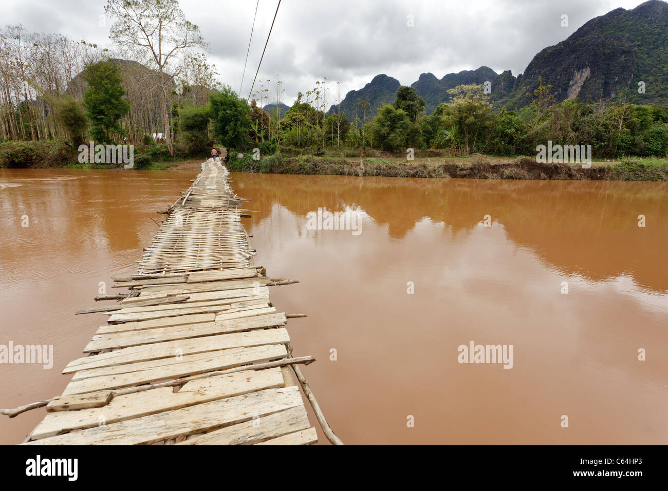 wooden bridge on Nam Song river under cloudy weather in vang vieng, laos Stock Photo