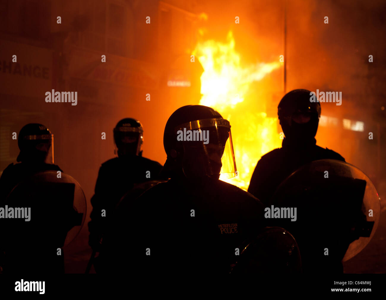 Police in Croydon in front of a burning building during the August 2011 riots Stock Photo