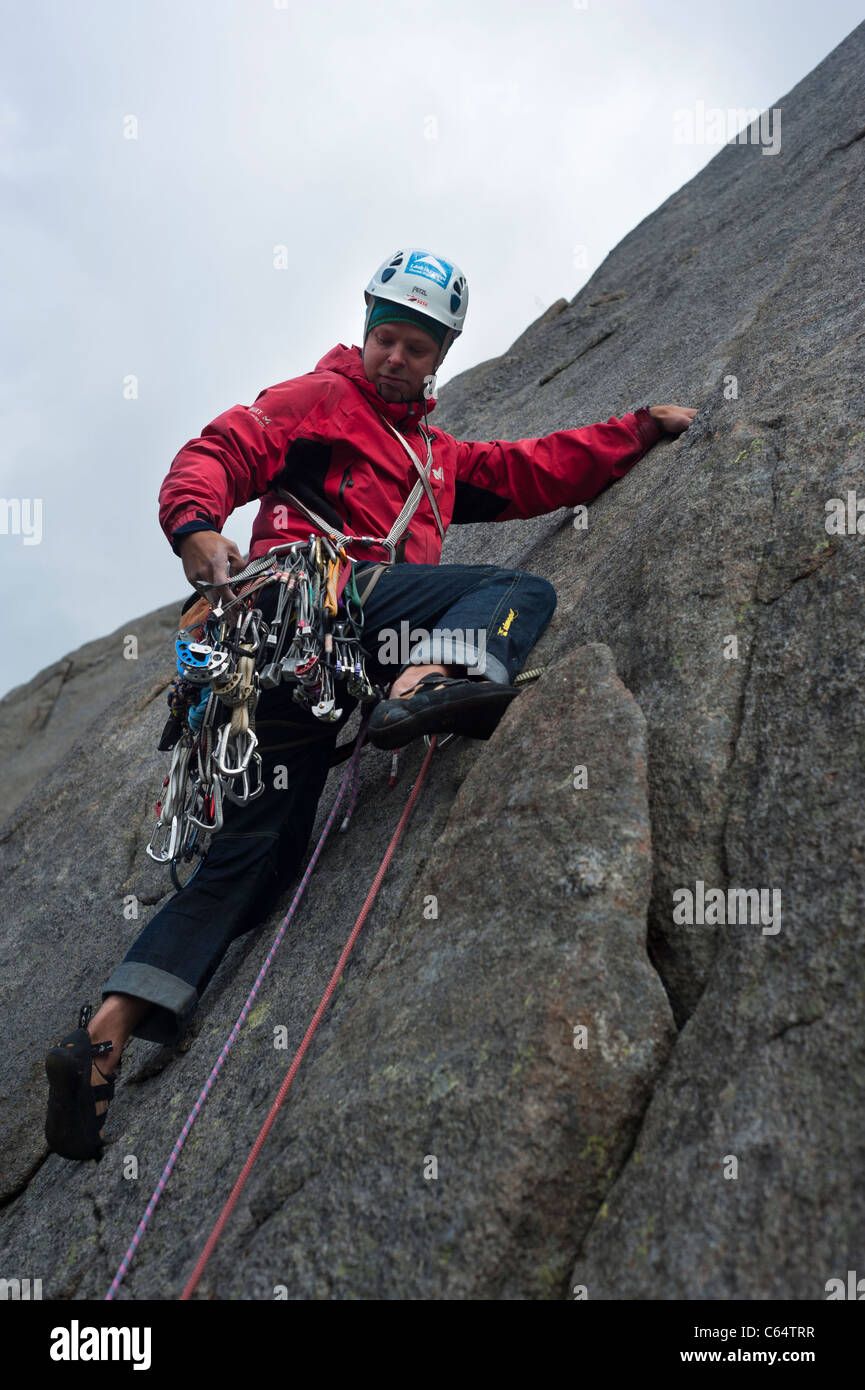 A male rock climber climbing in traditional style in Lofoten Islands ...