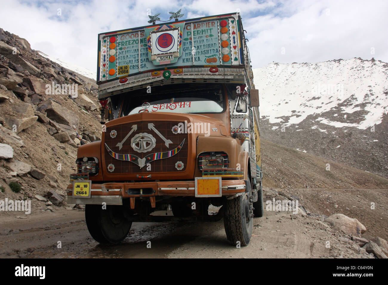 Decorated Tata goods carrier on the snow capped mountain road in the Himalayas Ladakh northern India Stock Photo