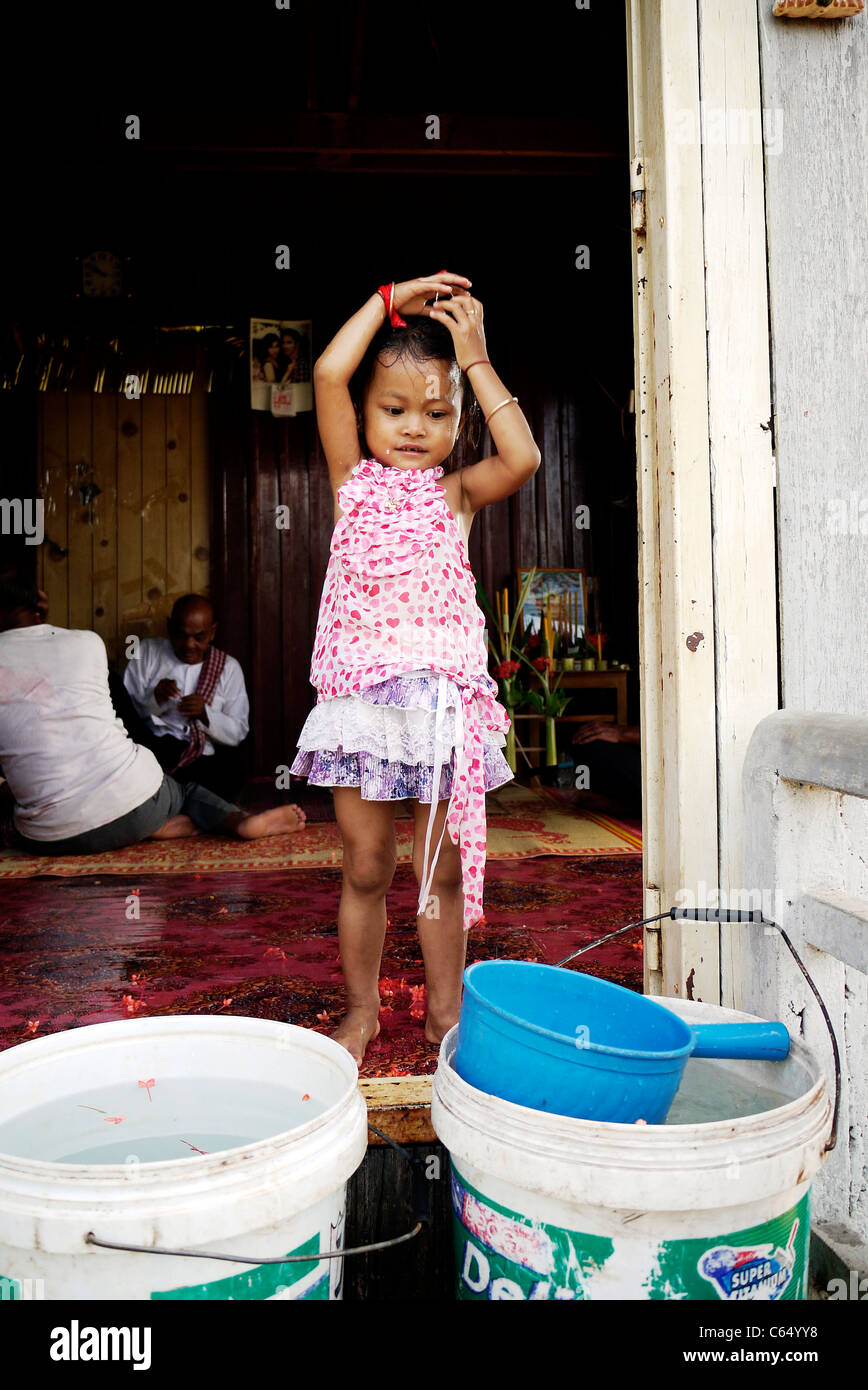 Girl, child, playing, taking a bath, Cambodian, home,sit, wall, Stock Photo