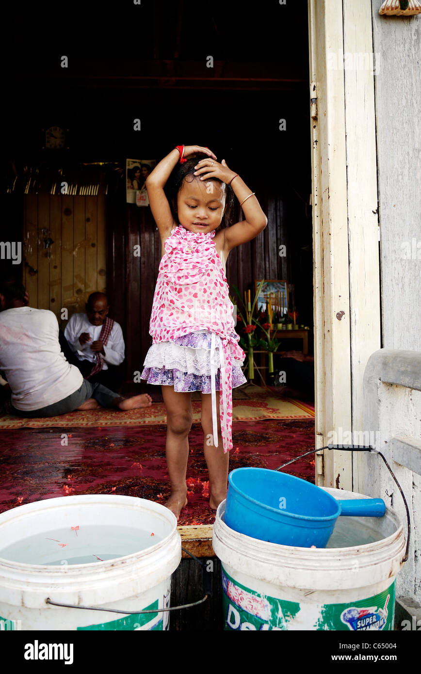 Girl, child, playing, taking a bath, Cambodian, home,sit, wall, Stock Photo